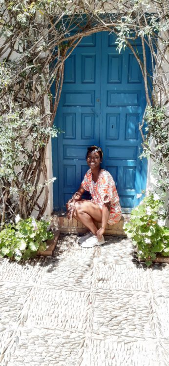 Naomi voor een authentieke blauw deur.