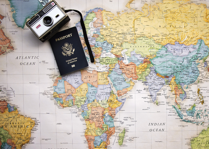 Wat kan er fout gaan op reis: op de afbeelding zie je een wereldkaart, camera en een paspoort
