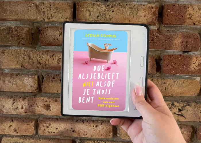 Je ziet een ereader met het boek 'Doe alsjeblieft (niet)alsof je thuis bent' van Lydian Coppus.