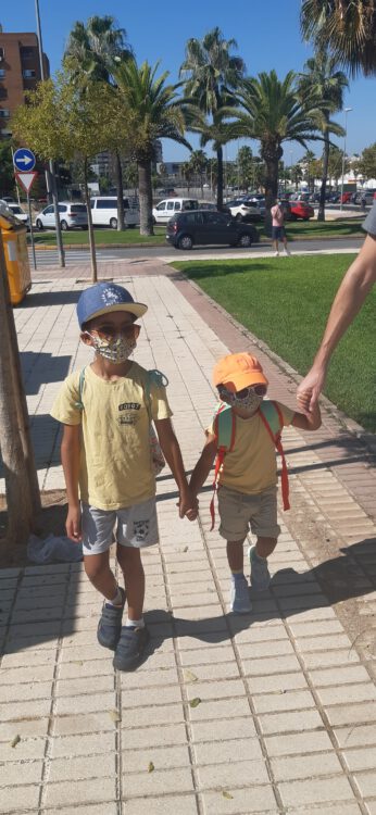 De zoons van Naomi met een mondkapje.